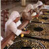 sowing gold thread on to the cloth to cover the Kabah